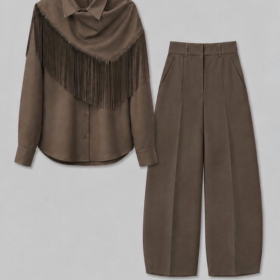 A two-piece women's outfit set in a warm taupe-brown color, featuring a long-sleeve button-up shirt with a draped collar and fringe detail, paired with high-waisted cropped trousers, laid flat on a light gray background.