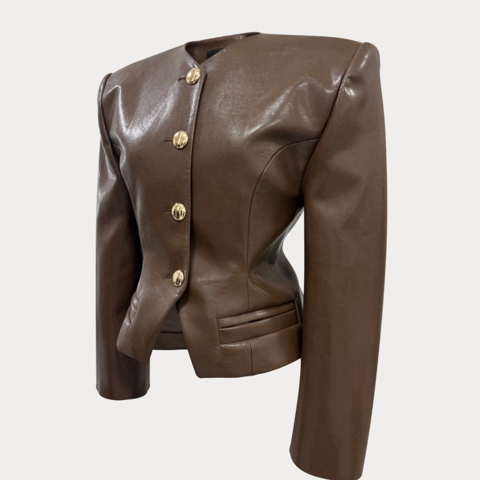 A cropped brown faux-leather jacket with structured shoulders, a round neckline, and a front button closure with gold-tone buttons, shown on a light gray background.