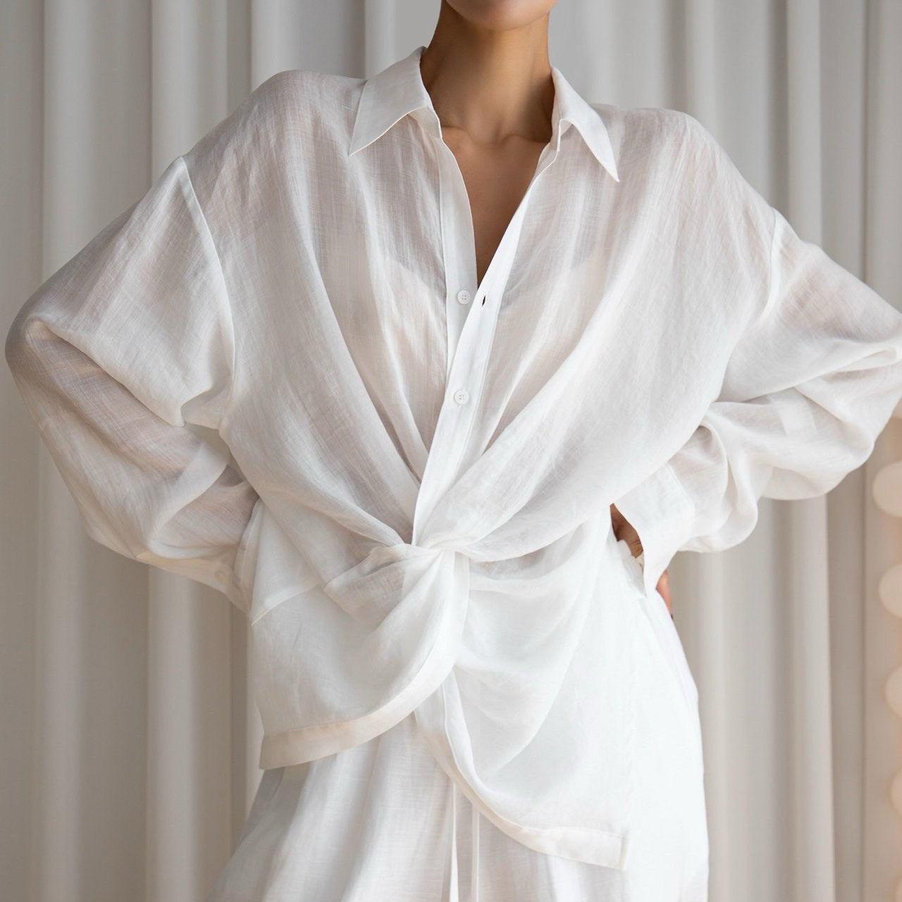 White shirt with a tie-waist design worn by a person against a neutral background