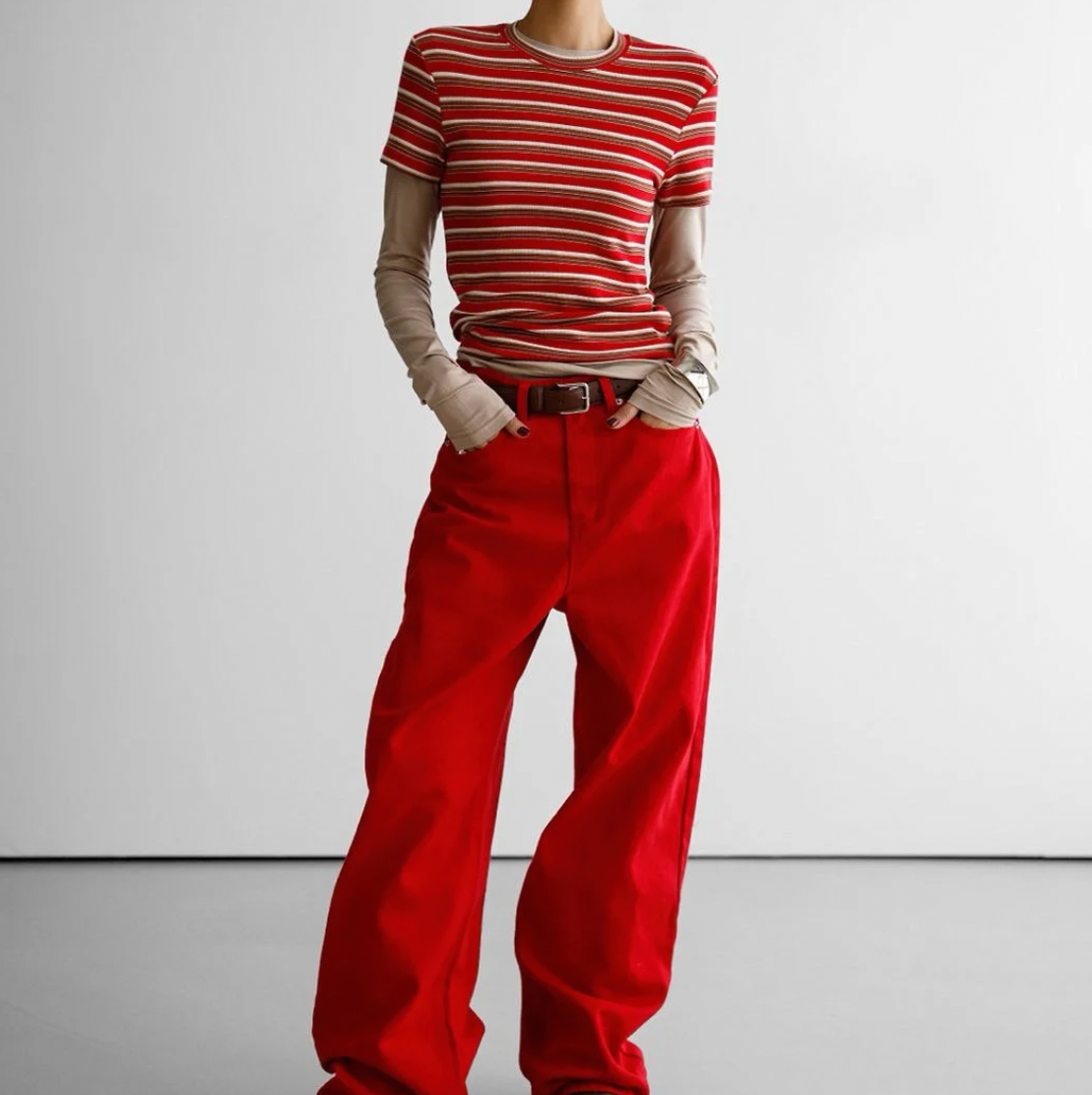 Person wearing a striped shirt and red pants on a white background