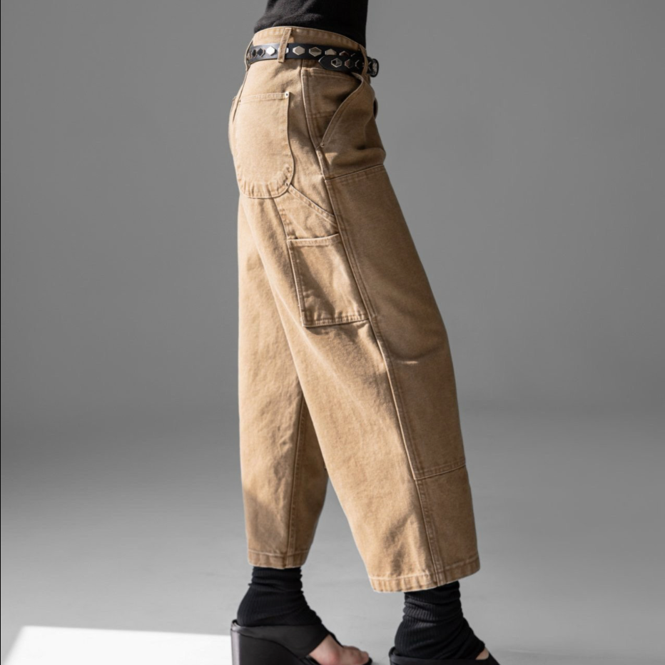 Person wearing beige cargo pants on a gray background