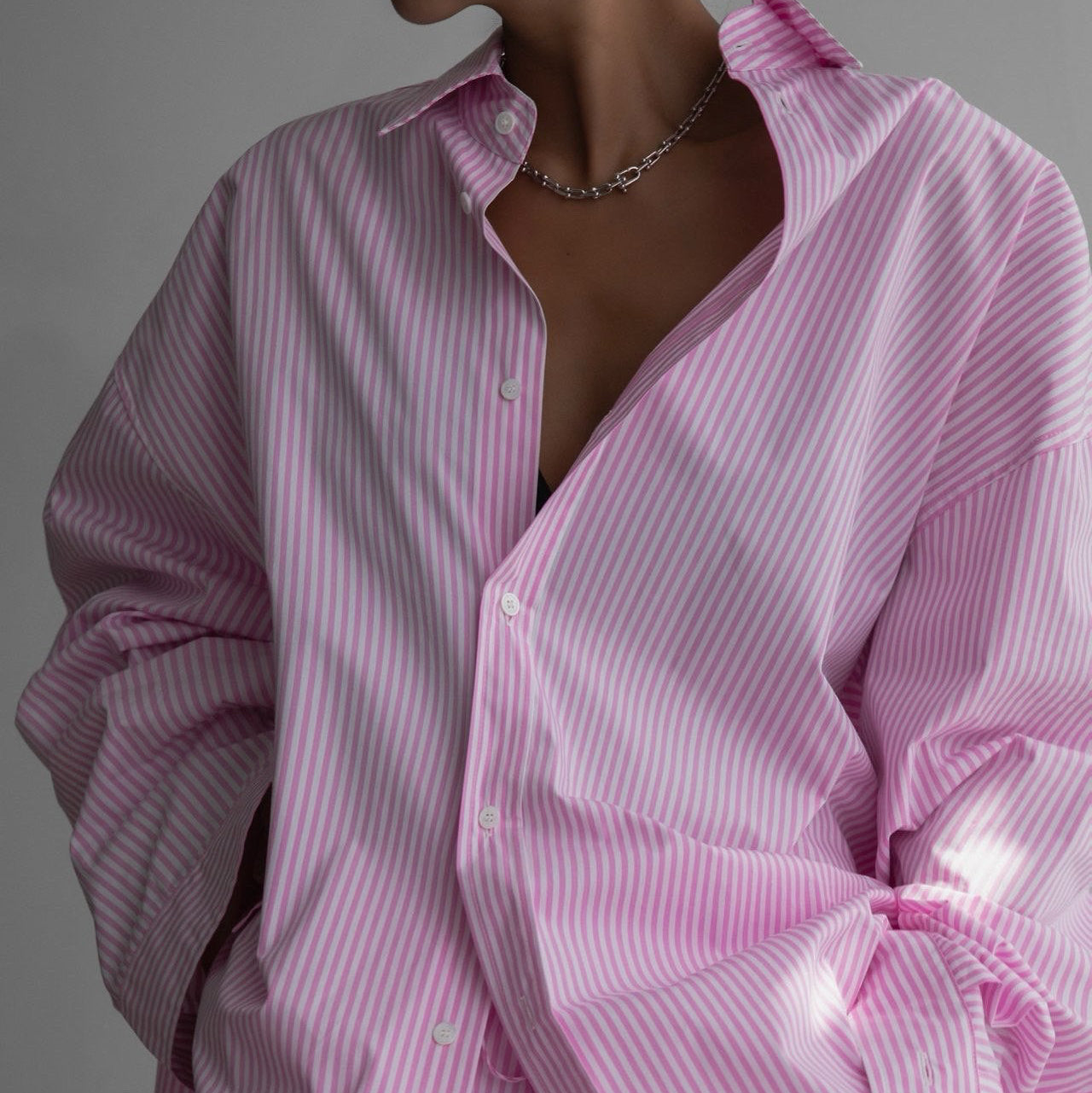 Pink striped shirt worn by a person on a gray background